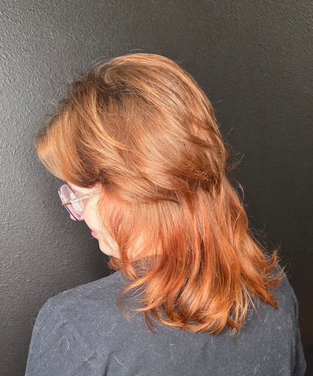 Side view of a copper-toned modern shag with short, textured layers on top and shoulder-length hair in the back.